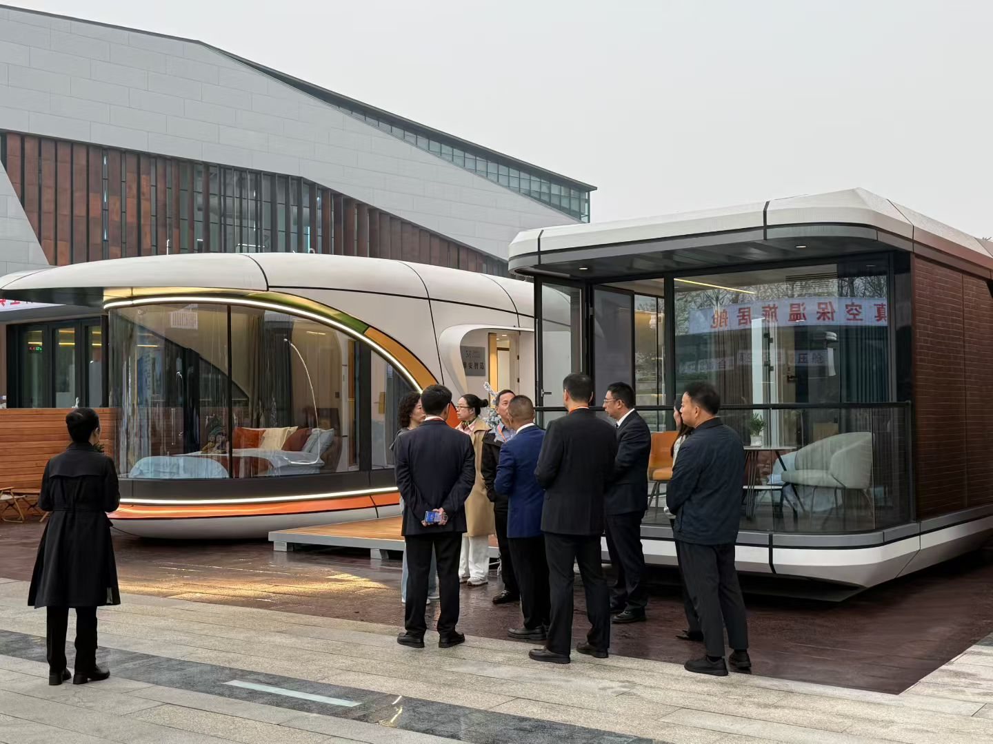 Visitors inspecting two space capsule cabin display units outdoors