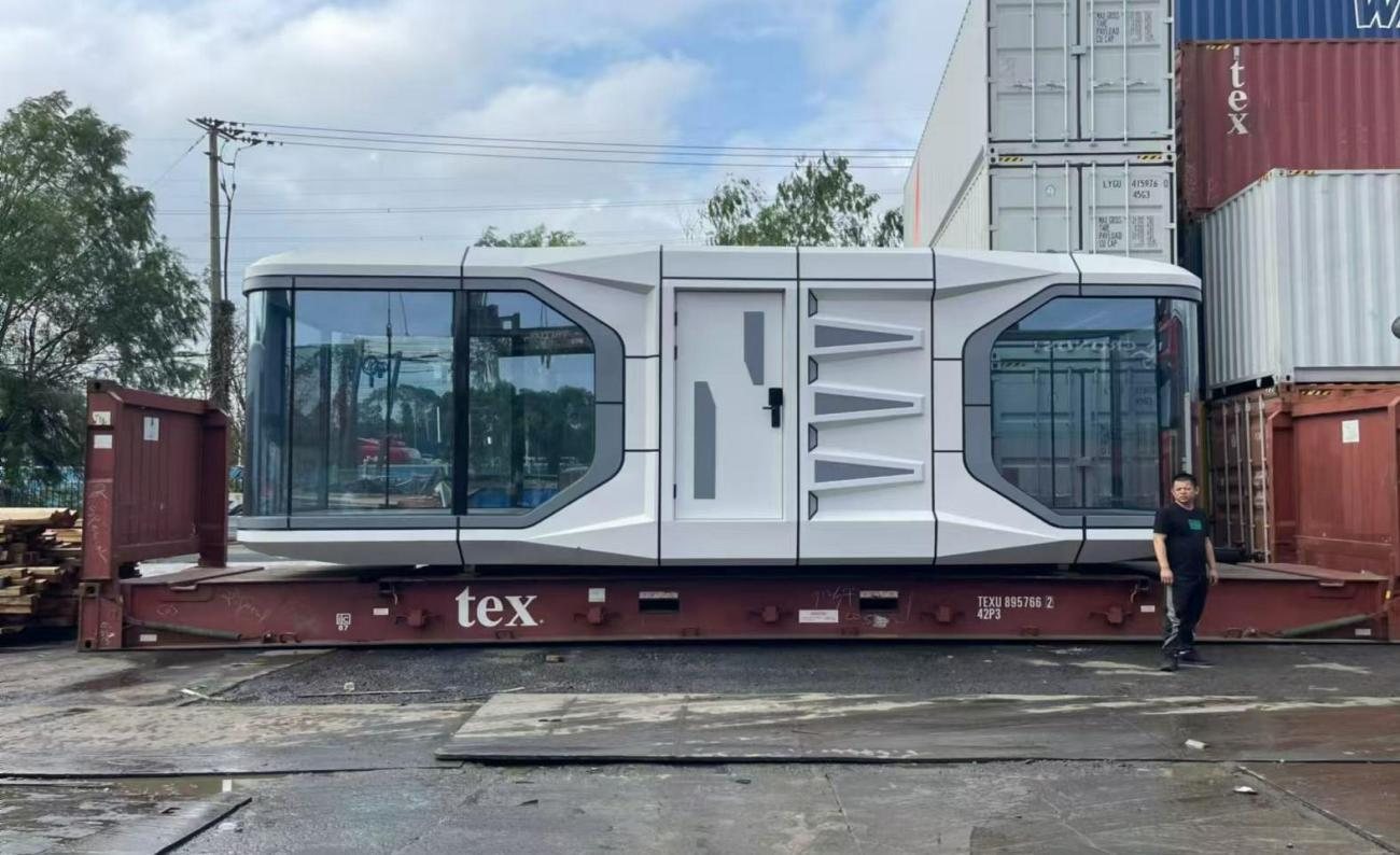 Space capsule cabin secured on a flat rack at a container yard