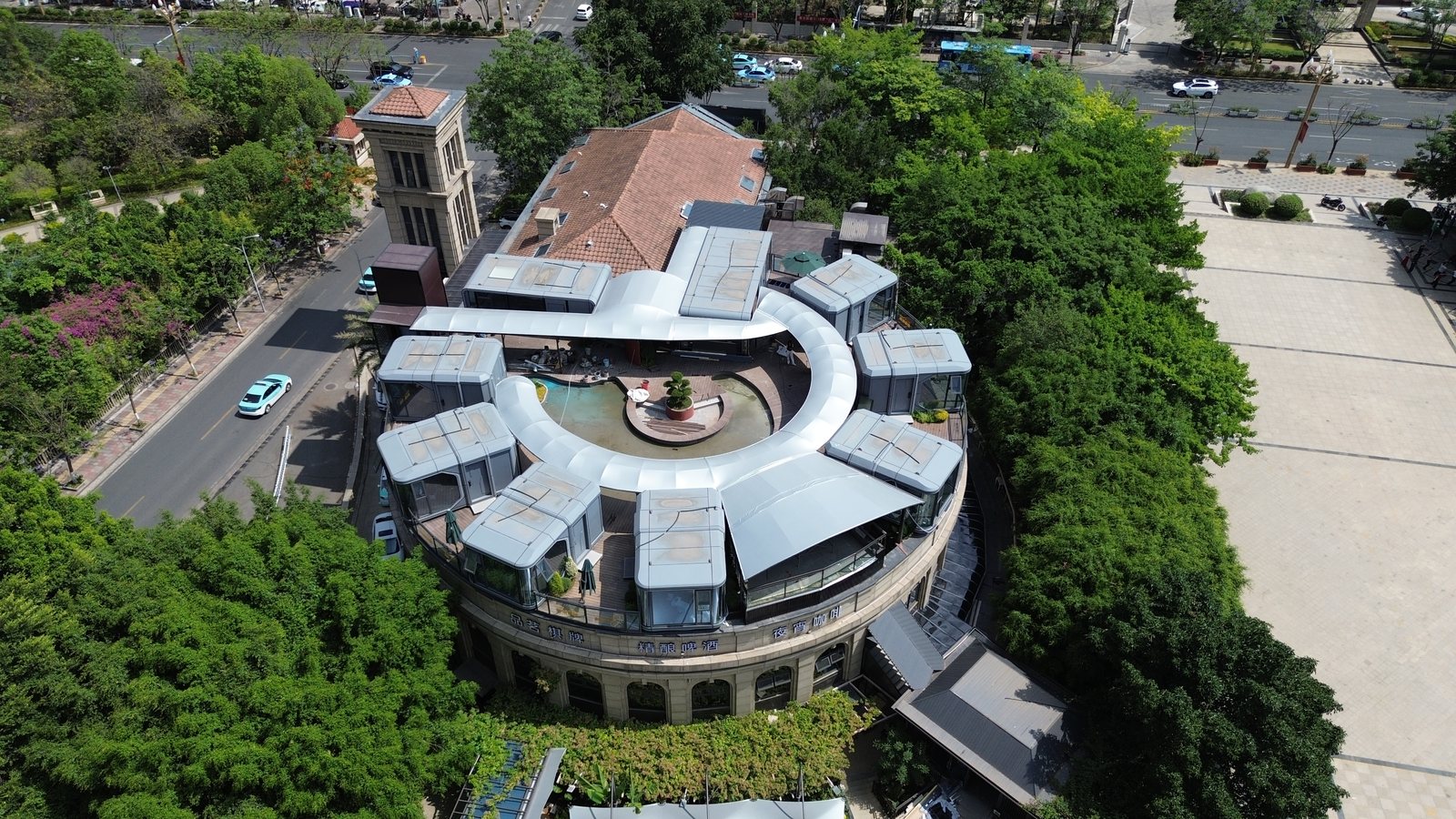 Aerial view of capsule cabins arranged around a circular rooftop courtyard